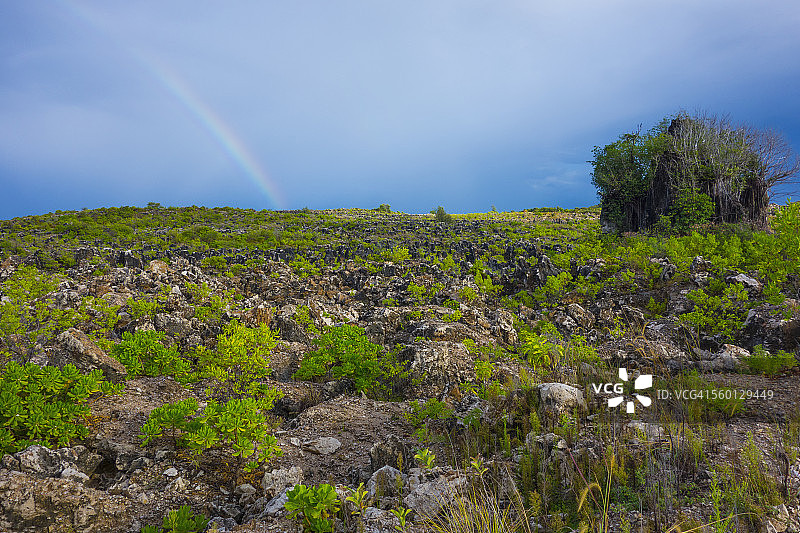 瑙鲁岛内陆的崎岖地貌与风暴云中的彩虹图片素材