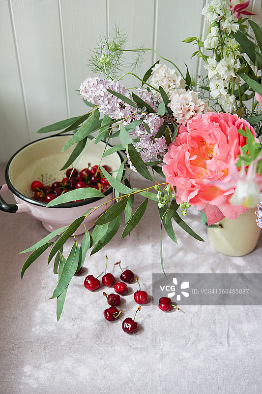 桌子上的樱桃和一束鲜花图片素材