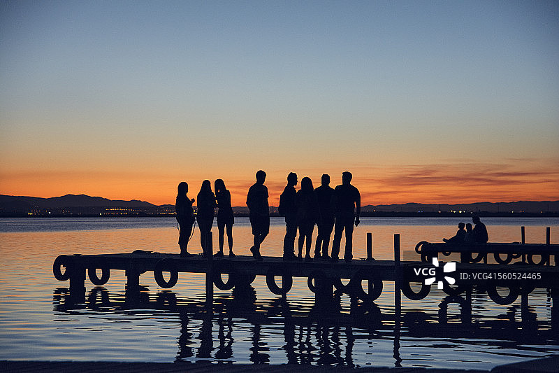 日落时码头上的人群剪影图片素材