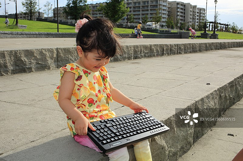 正在使用键盘的微笑婴儿图片素材