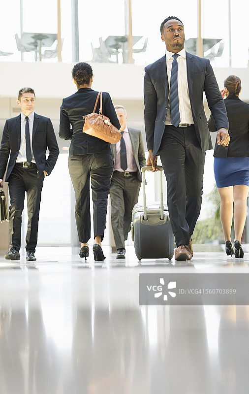 商务人士在机场拖着行李走路图片素材