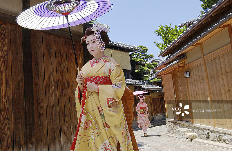 两位艺伎撑伞走在街上图片素材