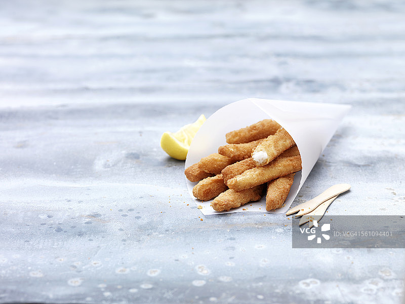 钢桌上放有防油纸锥和柠檬鳎鱼图片素材