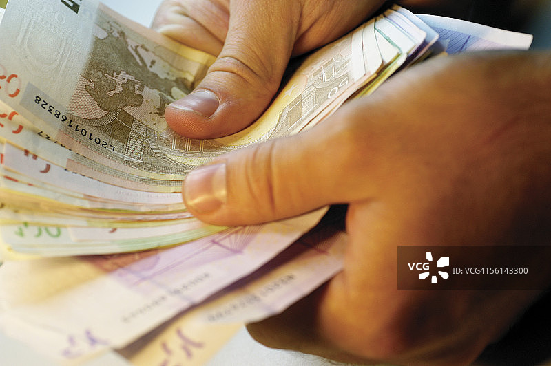 男人拿着几张欧元纸币特写图片素材