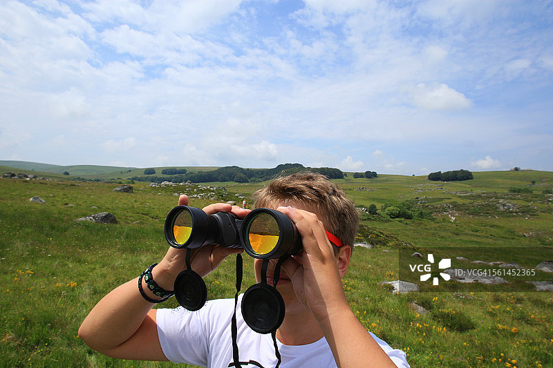 年轻男人在南方用双筒望远镜观察图片素材