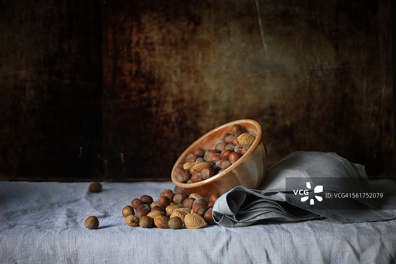 灰色亚麻布上的坚果碗图片素材