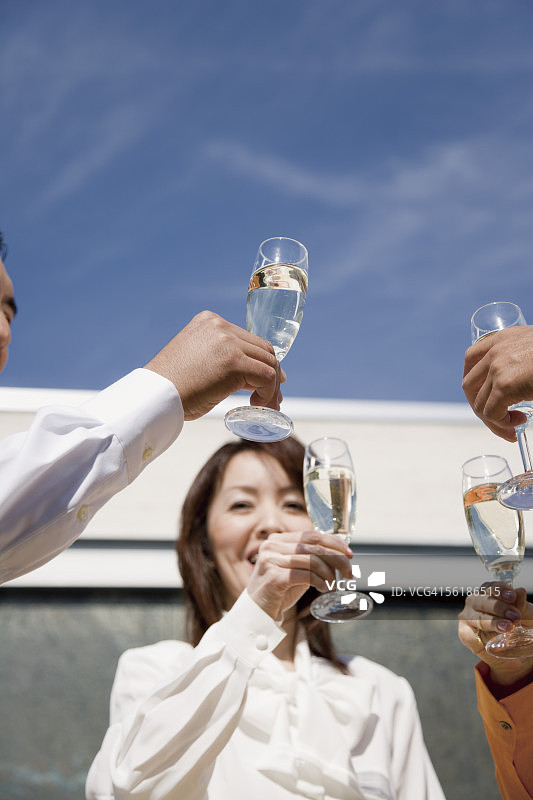 一小群人举起香槟酒杯，特写镜头图片素材