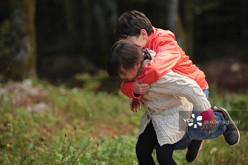森林里小妹妹背着哥哥图片素材