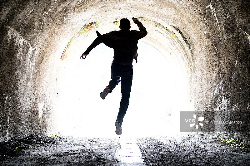 男人跑向隧道出口图片素材