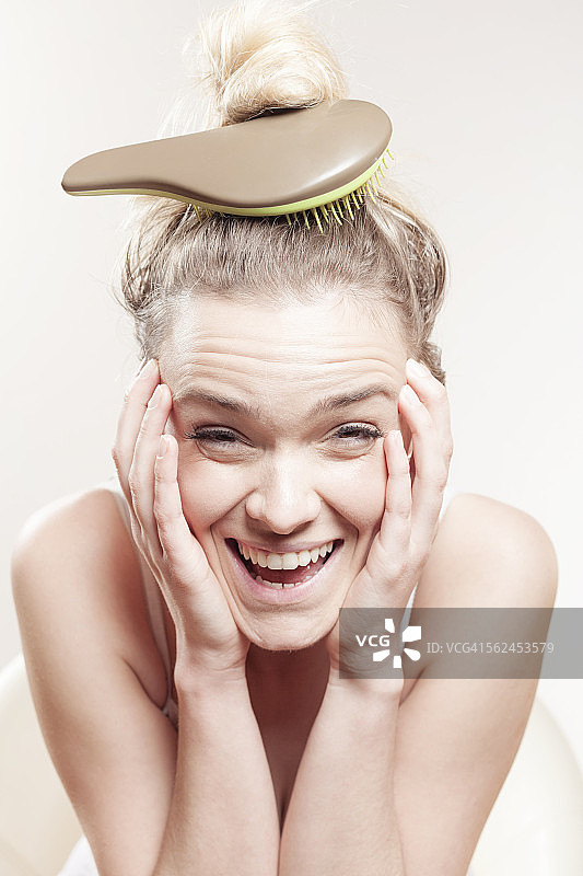 头顶发刷的年轻女人图片素材