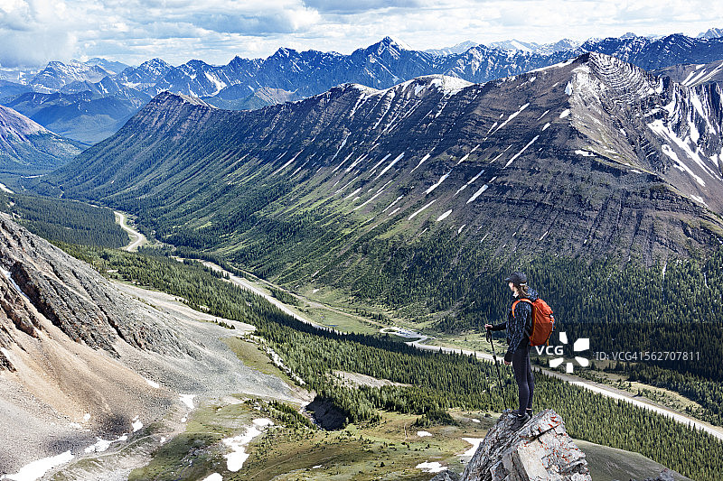 妇女徒步旅行者站在山谷岩石上图片素材