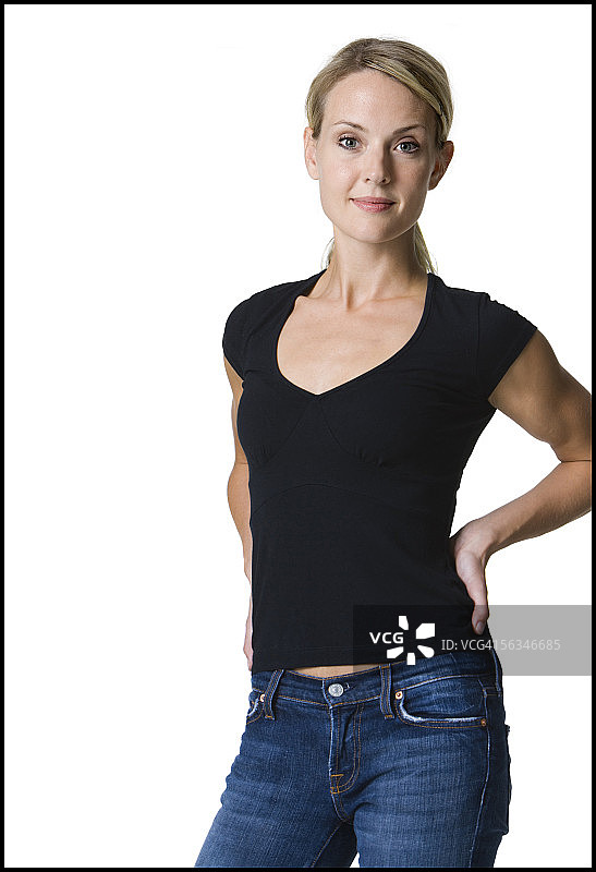 年轻女子站立着，双手放在背后图片素材