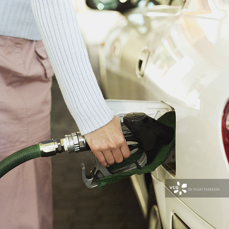 女人给汽车加油的腰部视角图片素材