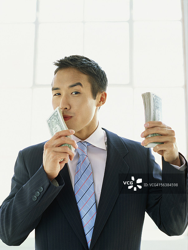 商人亲吻金钱的肖像照图片素材