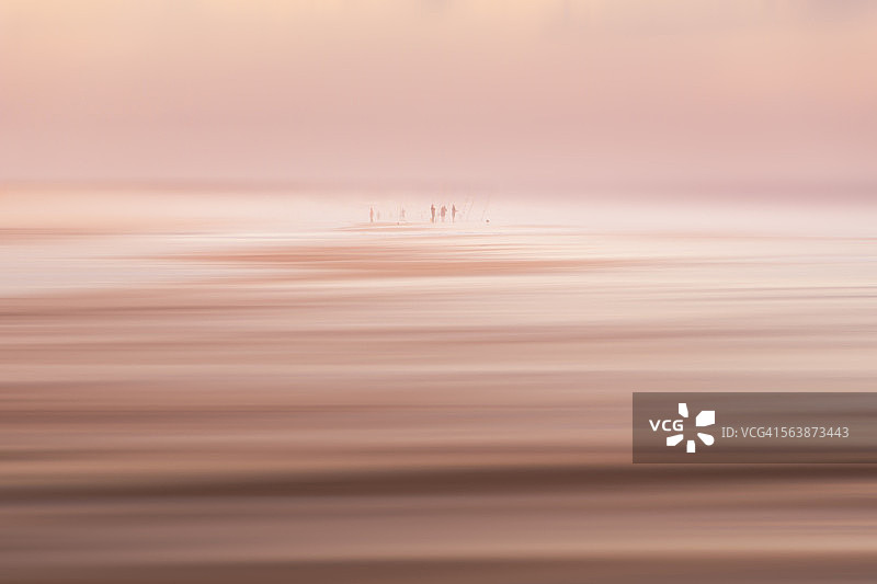 人们在清晨的海滩钓鱼图片素材