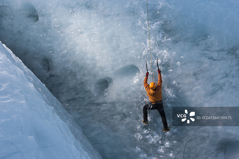 男子攀登垂直冰川冰墙图片素材