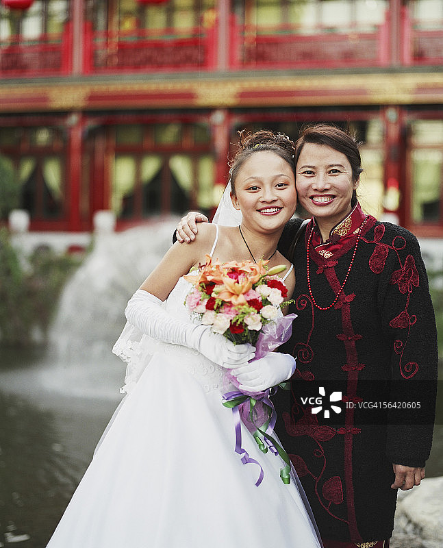 身穿婚纱的年轻女子与另一名女子合影图片素材