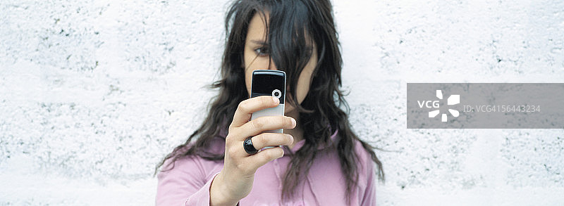 使用拍照手机的年轻女人图片素材