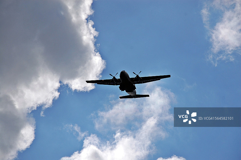 多云天空下的螺旋桨飞机图片素材