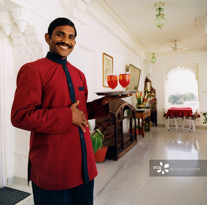 端着饮料托盘的微笑服务员图片素材