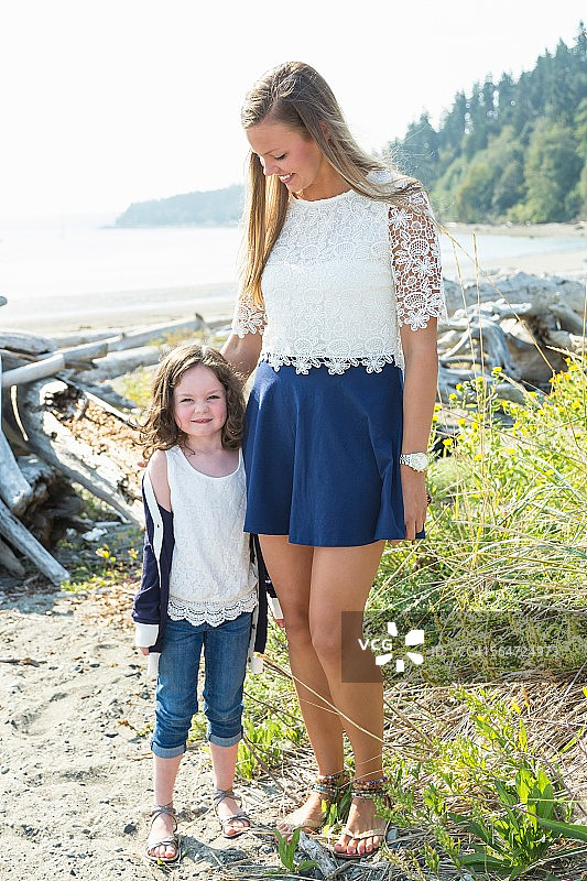 在海滩上的年轻女子和女儿的肖像图片素材