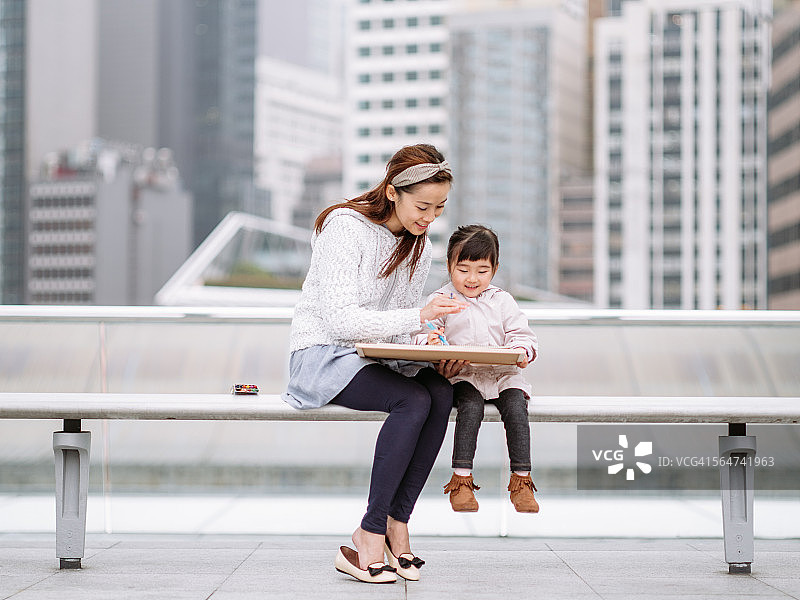 小女孩和妈妈在屋顶花园画画图片素材