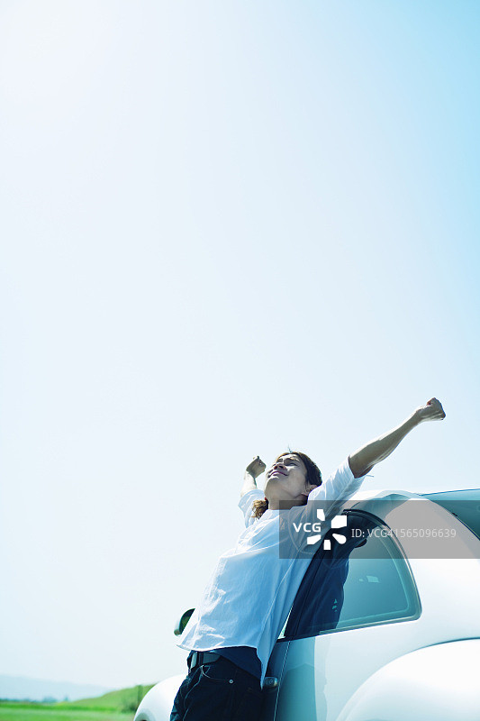 年轻男人倚靠在汽车旁图片素材