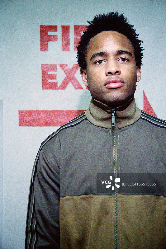 在消防出口标志旁的年轻男人图片素材