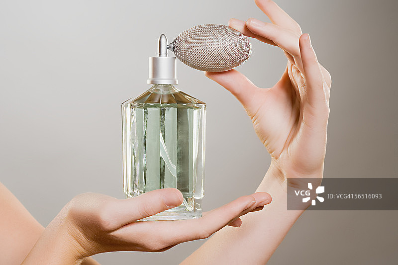 手拿香水瓶的女人图片素材