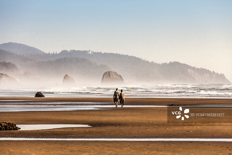 两人在美国俄勒冈州坎农海滩漫步图片素材