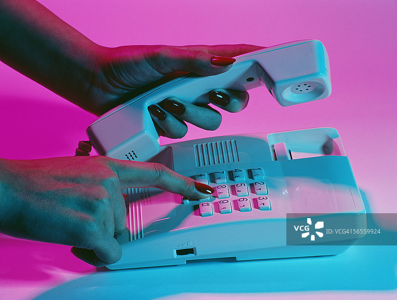 女性拿着电话听筒拨号图片素材