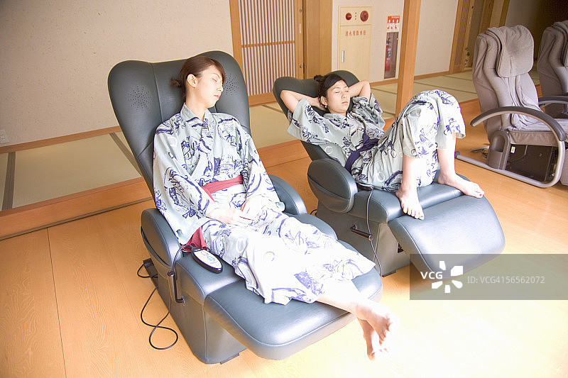 两名年轻女子在按摩椅上放松图片素材