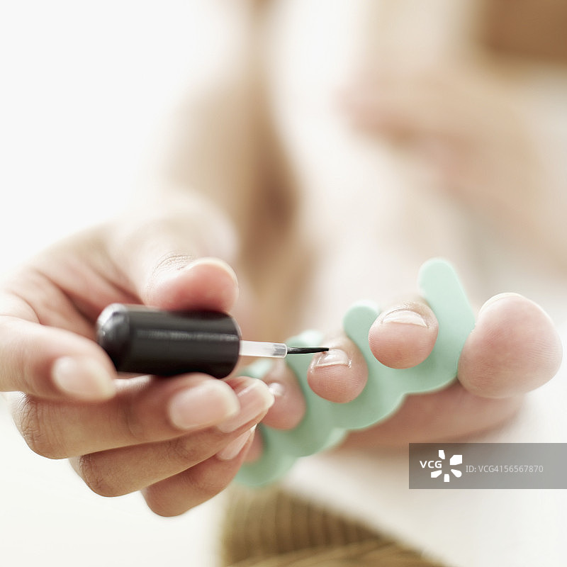 特写：女人涂抹脚趾甲图片素材