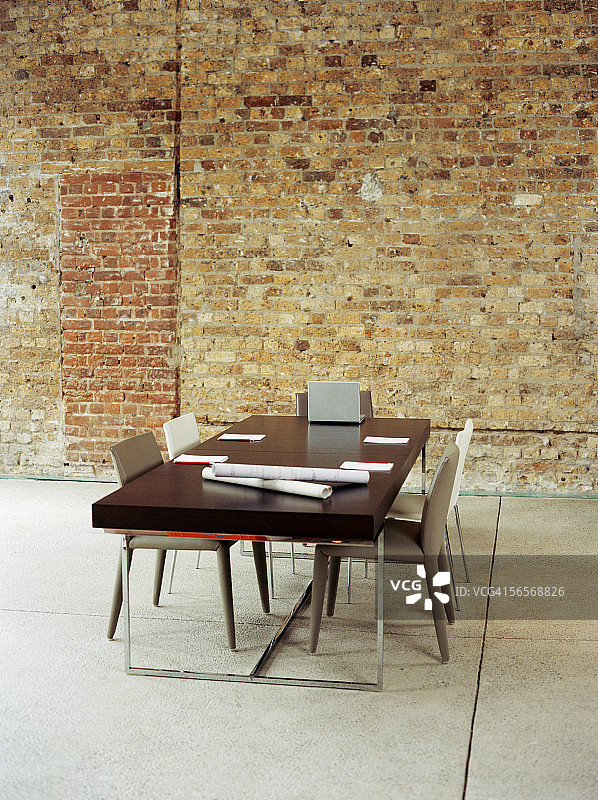 会议桌上的笔记本电脑和蓝图便笺簿图片素材