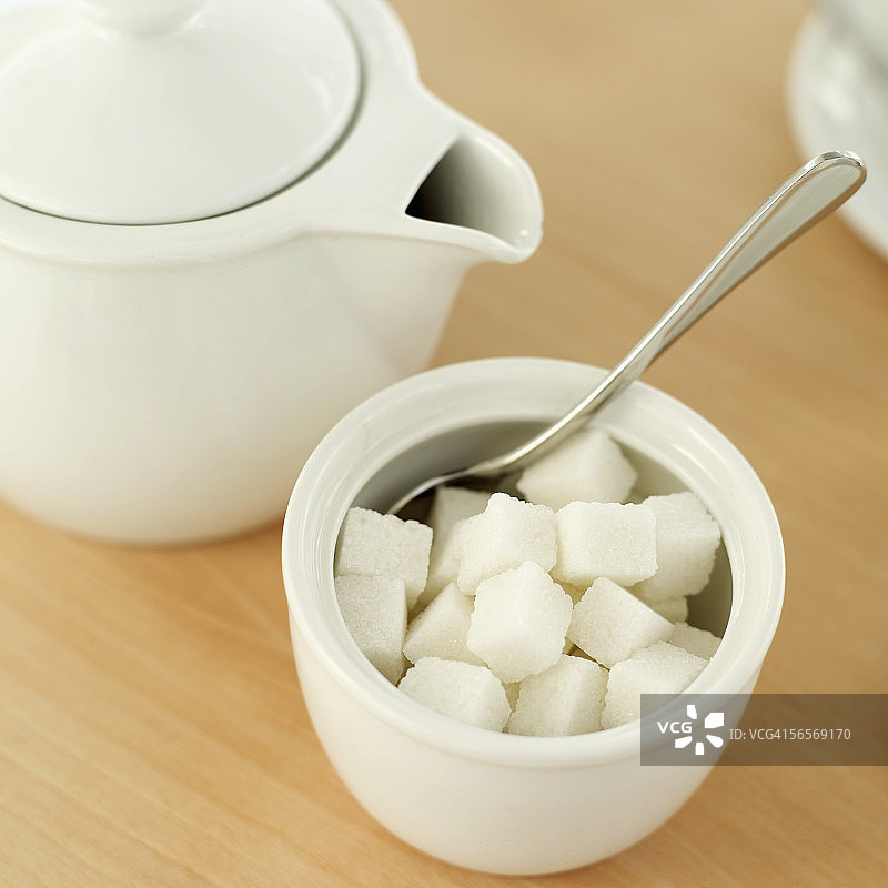 茶壶和一碗方糖及勺子的高角度景观图片素材