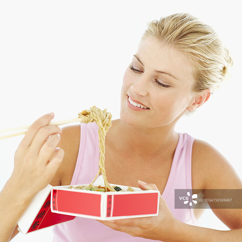年轻女人用筷子夹面条图片素材
