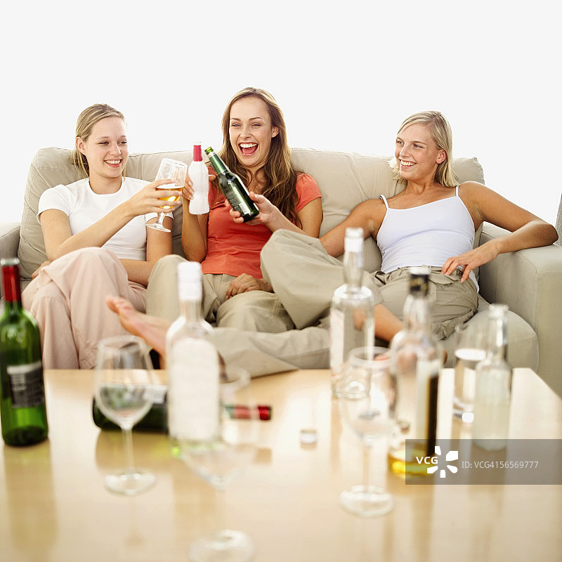 三个年轻女子坐在沙发上敬酒图片素材