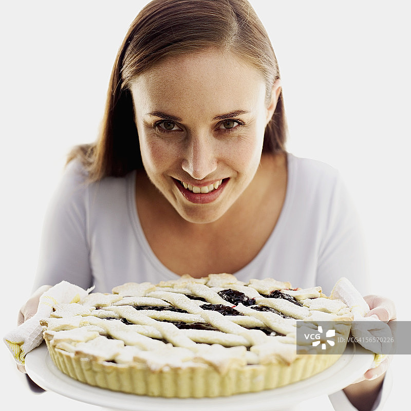 年轻女子手捧新鲜出炉馅饼的肖像图片素材