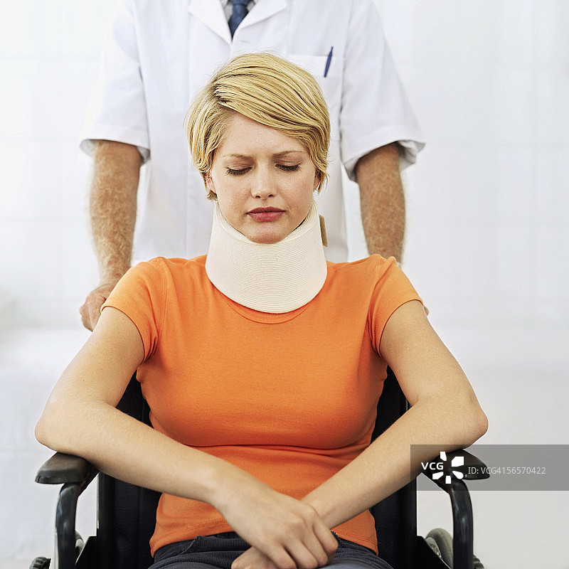 年轻女人坐在轮椅上，戴着颈托图片素材