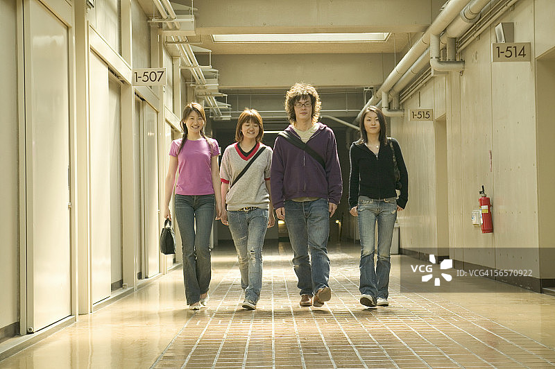 四个大学生走在走廊里图片素材
