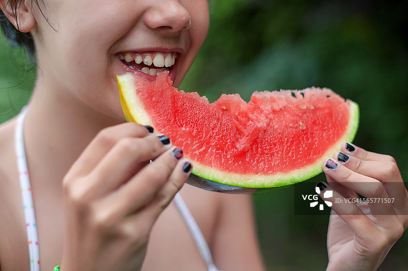 正在吃一大块西瓜的白人女孩图片素材