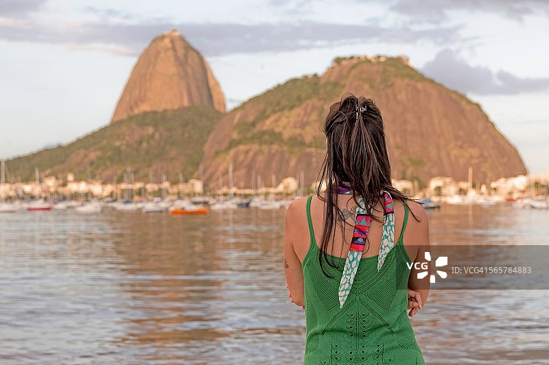 中年妇女眺望巴西里约热内卢博塔弗戈海湾的糖面包山图片素材