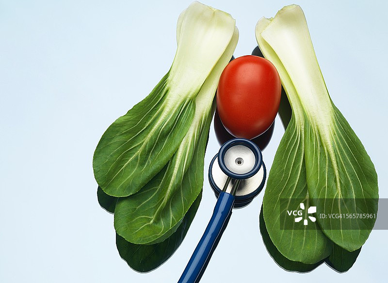 医疗托盘上的听诊器，配有番茄和小白菜，用于说明健康的肺和心脏图片素材
