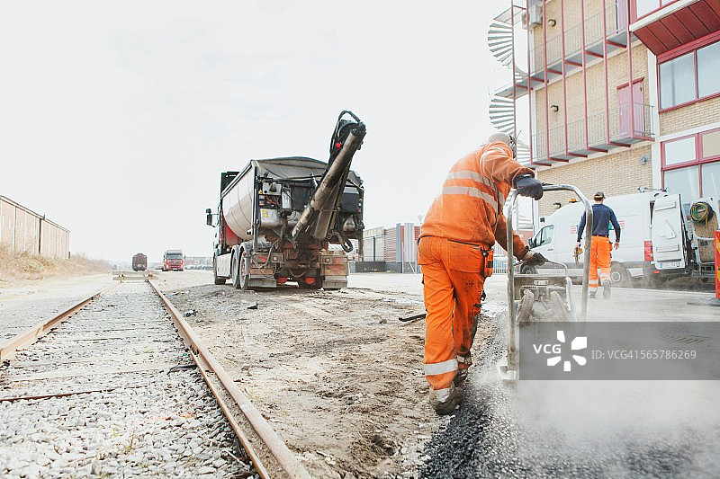 工人在建筑工地铺设沥青图片素材