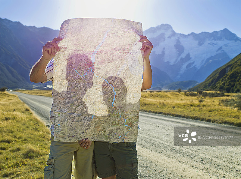 情侣在偏僻的道路上阅读路线图图片素材