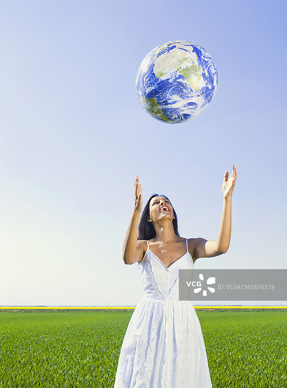 在乡村田野里玩地球仪的印度妇女图片素材