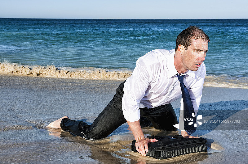 带着公文包在海滩上爬行的潮湿的白人商人图片素材