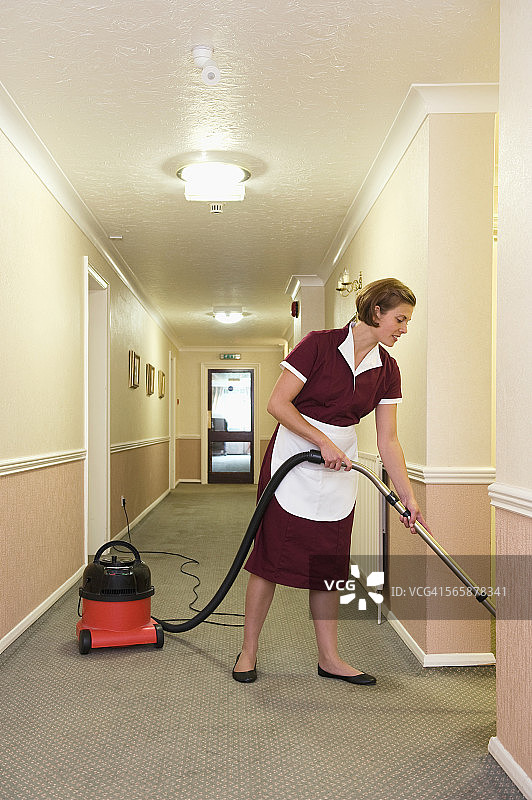 白人女佣在酒店走廊吸尘图片素材