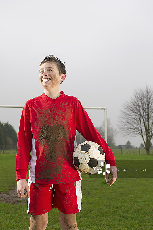拿着足球在球场上的白人男孩图片素材
