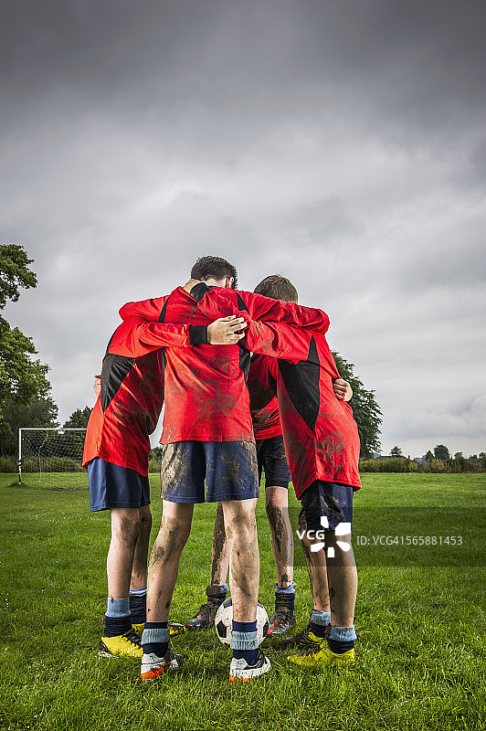 在球场上围成一圈交谈的白人足球队图片素材